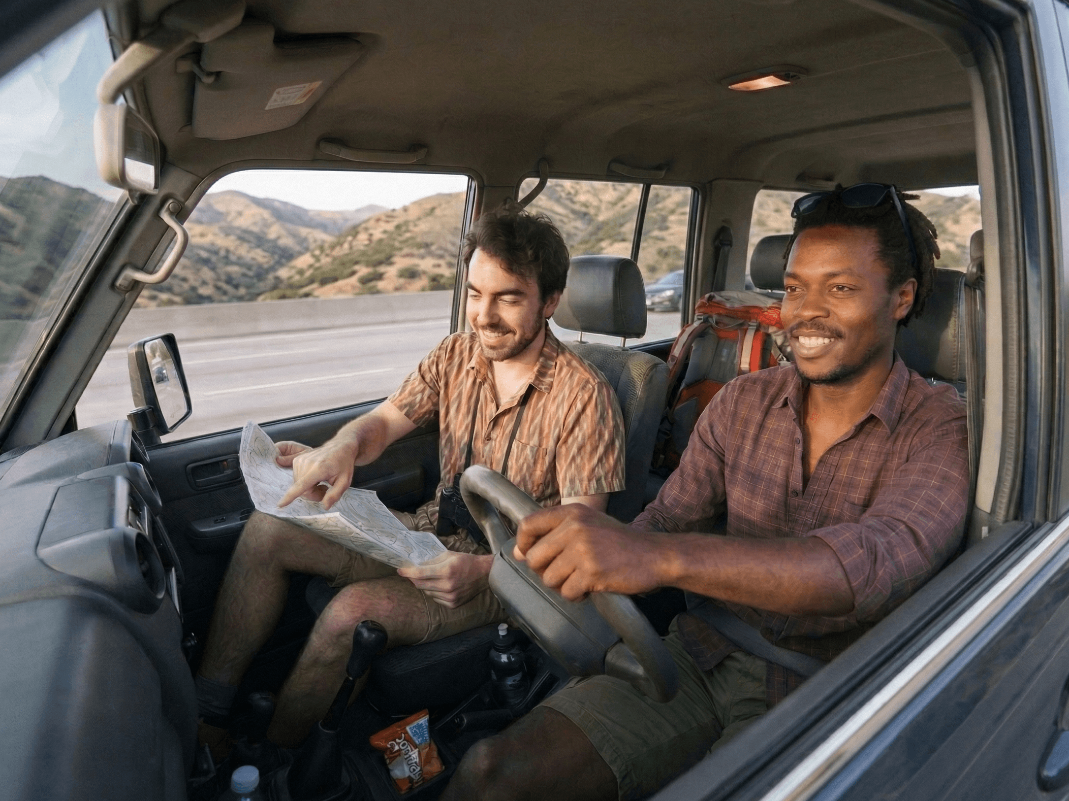 Two friends driving in a car ready to go on a hiking adventure